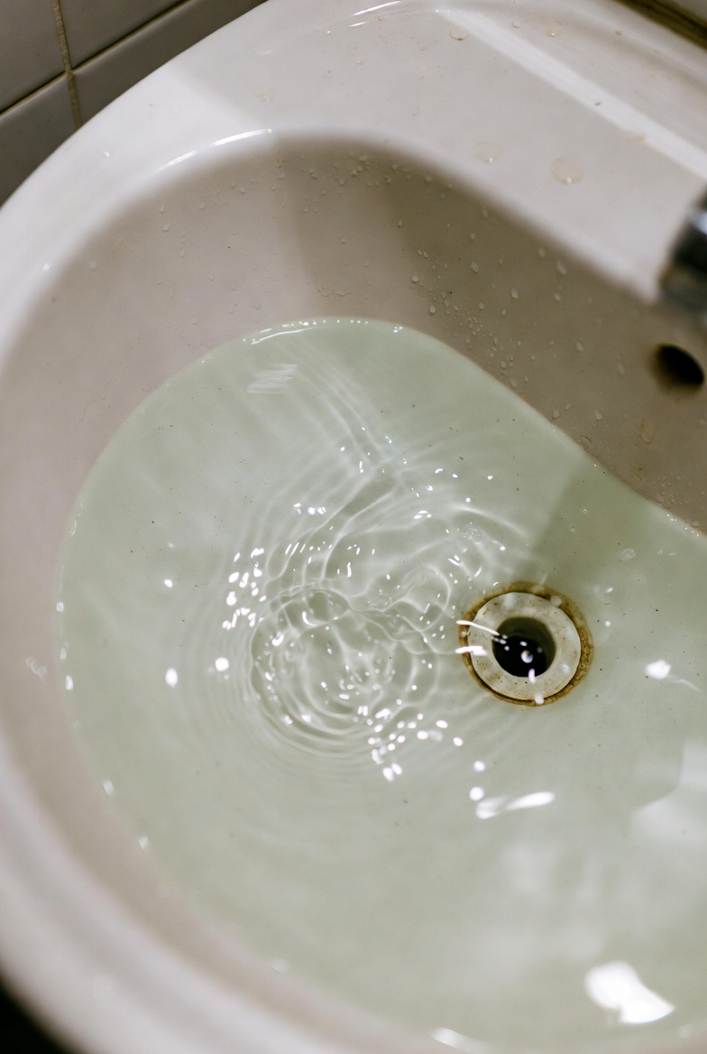 Soap scum buildup inside bathroom sink drain
