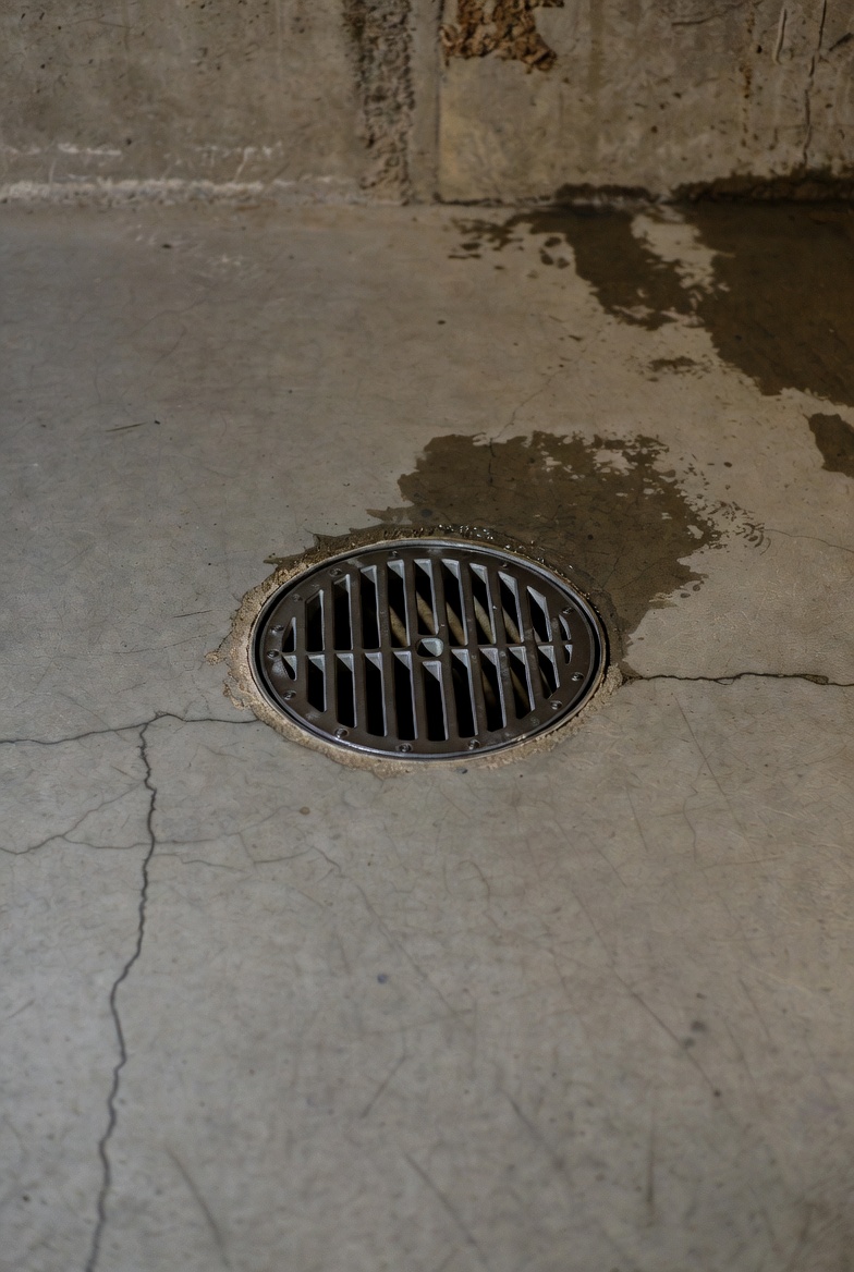 Pile of plumbing parts and common mistakes annotated on a basement floor plan