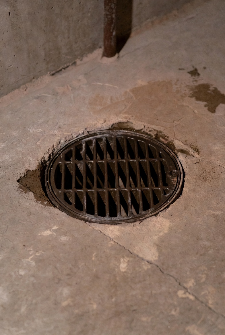 Basement corner with a sump pump and a marked backwater valve on a wall diagram