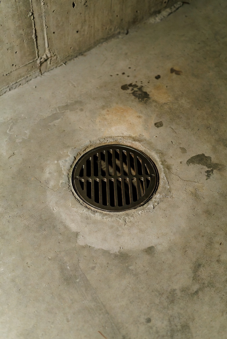Plumbing: night scene of basement floor and laundry drains with standing water